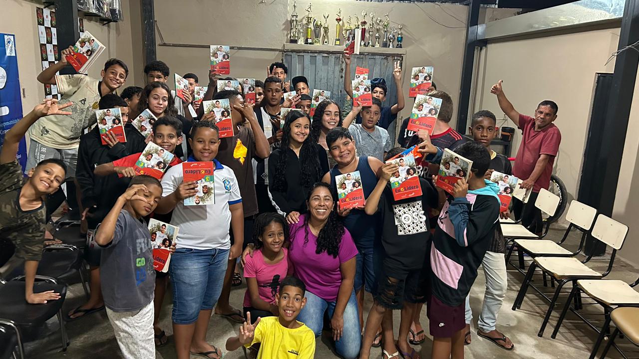 Jovens com livros do programa Eu Líder sorrindo